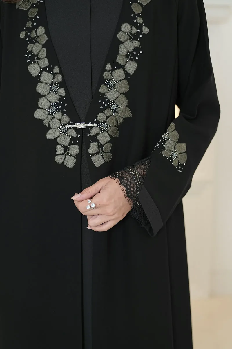A black abaya with floral embroidery and lace cuffs