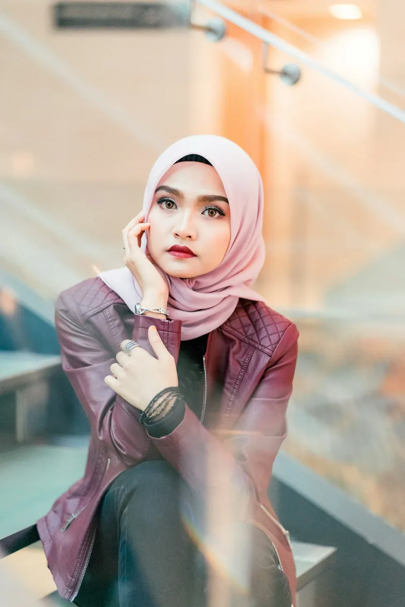 A blush scarf worn with a maroon jacket